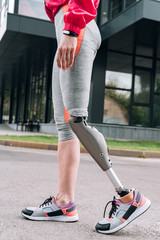 partial view of disabled sportswoman with prosthesis on street