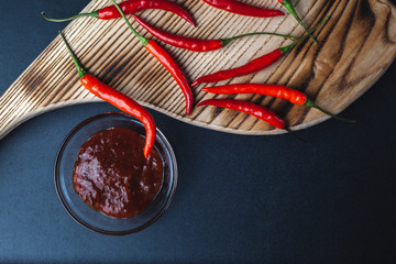 Hot red pepper lies on a cutting board on a black background. spicy Red Pepper Paprika Sauce