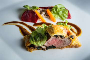 closeup modern dish of baked in dough meat with mushrooms