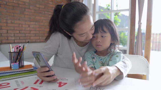 mother teaching basic math to her little daughter at home