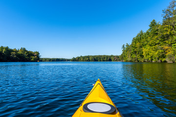 View from inside a kayak showing just the front along with the lake and surrounding forest