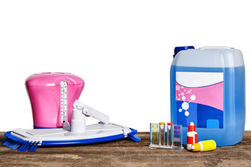 Equipment with chemical cleaning products and tools for the maintenance of the swimming pool on a wooden surface against white background.