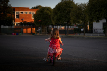 Little girl riding her bike at sunset
