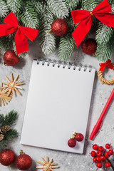 Fototapeta na wymiar Christmas or new year holiday background with open blank Notepad, fir branches and Christmas decorations. Free space for text