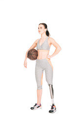 full length view of disabled sportswoman holding basketball ball isolated on white