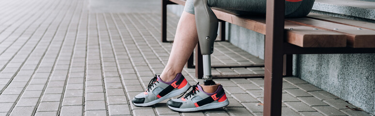 panoramic shot of disabled sportswoman with prosthetic leg on street - obrazy, fototapety, plakaty
