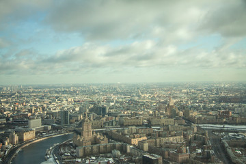 Top view of big city in the winter. Urban panorama of cityscape and blue sky, groups of buildings.