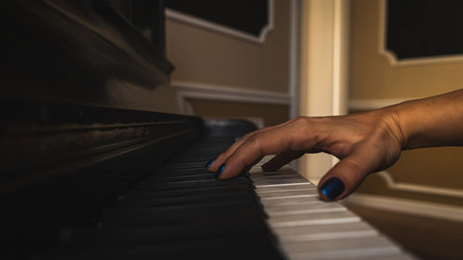 Naklejka na ściany i meble Playing the piano, hand close-up shot