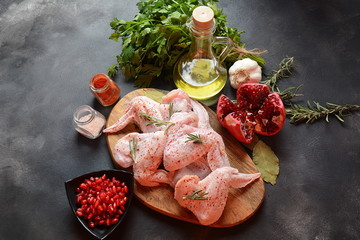 Raw uncooked chicken wings for barbecue grill with salt, herbs, garlic and olive oil. Meat with ingredients for cooking