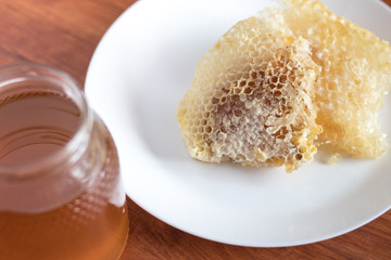Fresh honey jar with flowers and honeycomb, delicious biological product.