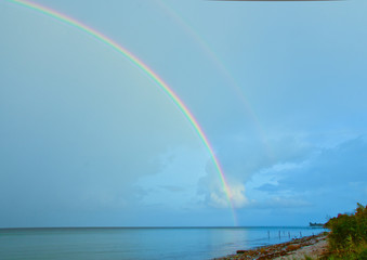 Beautiful, bright, lucent and real rainbow across the ocean