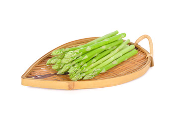 fresh asparagus in bamboo plate on white background