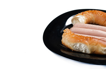 Hot dog with ketchup and mayonnaise on black plate isolated on white background.Breakfast.