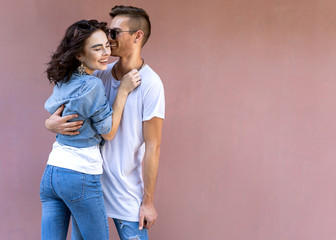 Naklejka premium fashion couple in sunglasses posing on pink wall