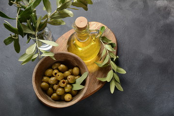 Extra virgin Olive oil , olive branch and olives on a dark background