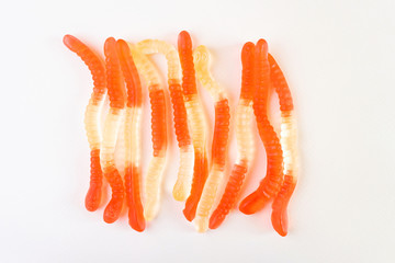 Jelly worms on a light background. The concept of junk sweets, candies. Minimalism, top view, flat...