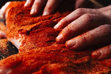 Foto op Plexiglas Man preparing raw piece of meat, rubbing different spices and herbs in it before roasting © Marina P.