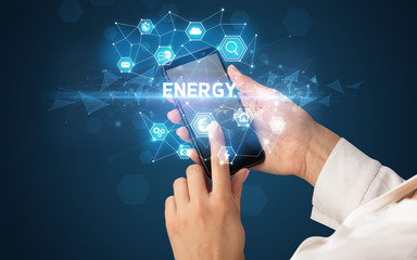 Female hand holding smartphone with ENERGY inscription, modern technology concept
