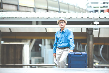 Fototapeta premium Portrait of happy senior mature man of travelers with luggage and map. Enjoying travel and happy tourism concept.