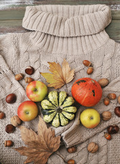 Autumn flat lay background. Pumpkins, apples, nuts,leaves, cups and sweater on wooden background.