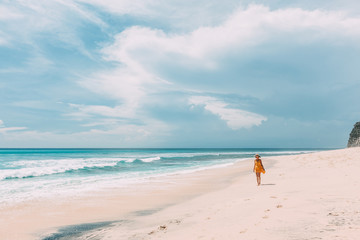 Obraz na płótnie Canvas Woman walking in blue lagoon with paradise view