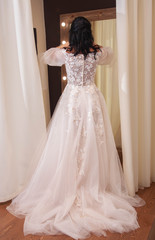 bride tries on wedding dress in wedding dress shop