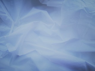 Wrinkled white fabric. Close-up photo. Abstract light background.