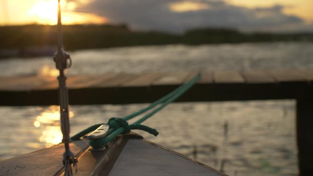 Sailboat docked on lake at sunset
