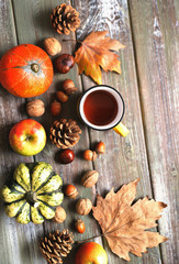 Naklejka na ściany i meble Autumn flat lay background. Pumpkins, apples, nuts,leaves, cups and sweater on wooden background.