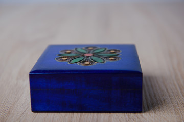 closed antique wooden blue jewelry box on the table