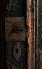 Closeup on open, old, wooden, green door with fixed vintage door handle