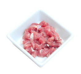 Raw pork slice in bowl on white background.
