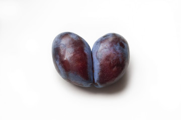 Ugly plum. Spoiled plum in the shape of a heart on a white background. Ugly fruit. Funny food. Spoiled food.