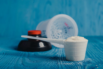 protein supplement powder in plastic spoon