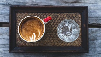 Cup of coffee with beautiful Latte art.On a wooden tray.