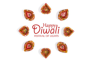 Happy Diwali - Clay Diya lamps lit during Dipavali, Hindu festival of lights celebration. Colorful traditional oil lamp diya on white background. Copy space for text.