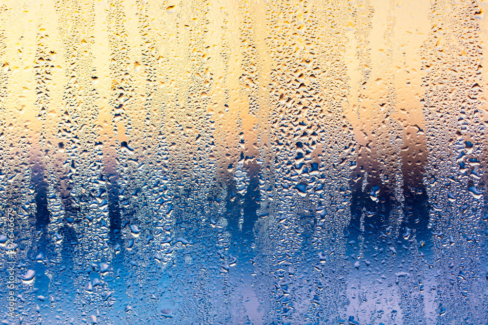 Wall mural A foggy window at sunset as an abstract background