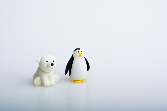 Penguin and polar bear rubber toys, cute animal shaped rubber doll isolated in white background. 