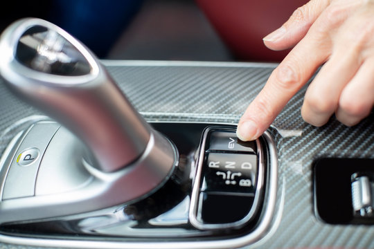 Close Up Of Driver Pressing Switch To Engage Electric Motor In Hybrid Car