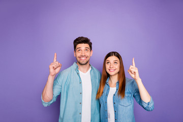 Portrait of romantic charming two married people students point up index finger at copyspace recommend choice decision advice sales wear trend clothes isolated over purple violet color background