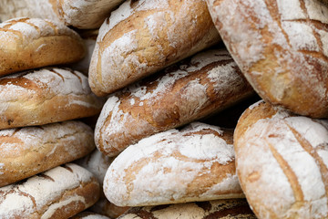 Pile of freshly baked wholemeal breads in the bakery or local farmer market.