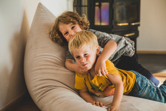 Zwei Kinder raufen im Wohnzimmer