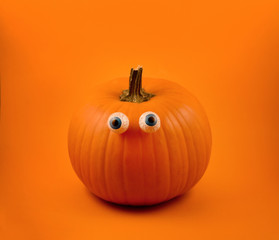 Halloween pumpkin with eyes stock images. Halloween pumpkin with eyes on a orange background. Cute...