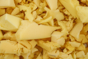 yellow polyurethane foam rubber pieces background texture. stuffing for pillows and furniture