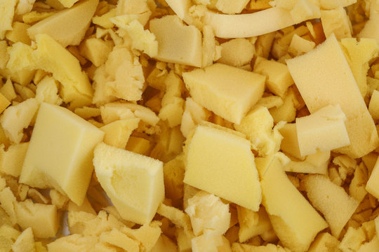 yellow polyurethane foam rubber pieces background texture. stuffing for pillows and furniture