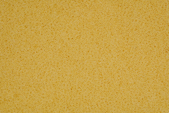 yellow polyurethane foam rubber pieces background texture. stuffing for pillows and furniture