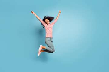 Obraz premium Full length body size profile side photo of screaming shouting cheerful cute nice girlfriend screaming with happiness jumping up isolated over blue pastel color background in striped t-shirt