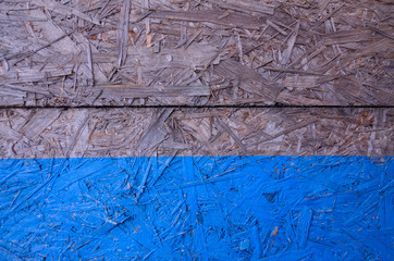 Blue Background. Natural wooden pressed shavings. Chipboard sheet close up, the background is empty