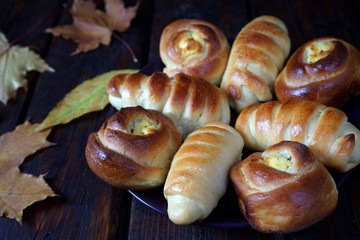 Homemade pastries with autumn leaves on a dark wooden table