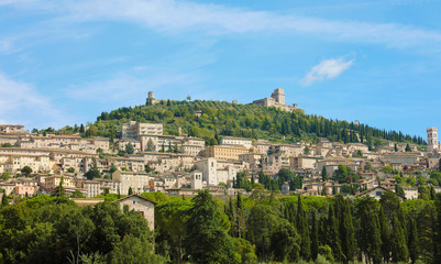 Fototapeta na wymiar Panoramic view of the historic town of Assisi in beautiful sunny day with blue sky and clouds in summer, Umbria, Italy.